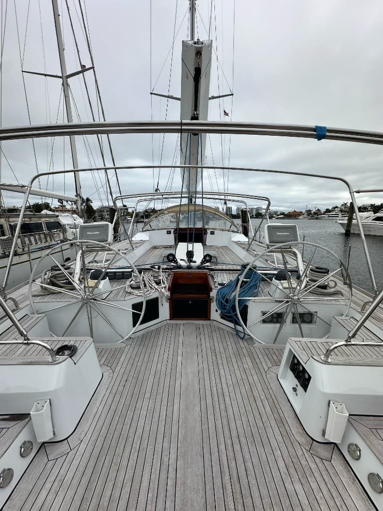 Dual-helm sailing yacht cockpit with teak decking and marina skyline beyond